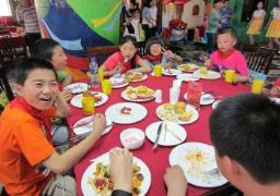 An SOS family sits down to eat together during a celebration. (photo: SOS archives)