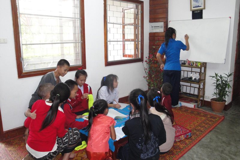 An older sister helps her siblings with their schoolwork (photo: SOS archives).
