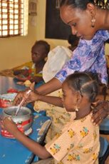 A teacher helps a little girl in the SOS Kindergarten in Dosso. (photo: SOS archives)